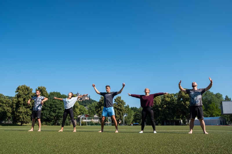 Studierende tanzen auf dem Sportplatz